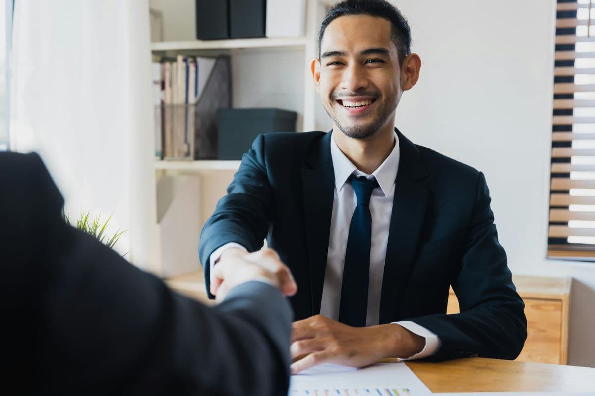 Person in suit shaking hands conveying trust in financial services
